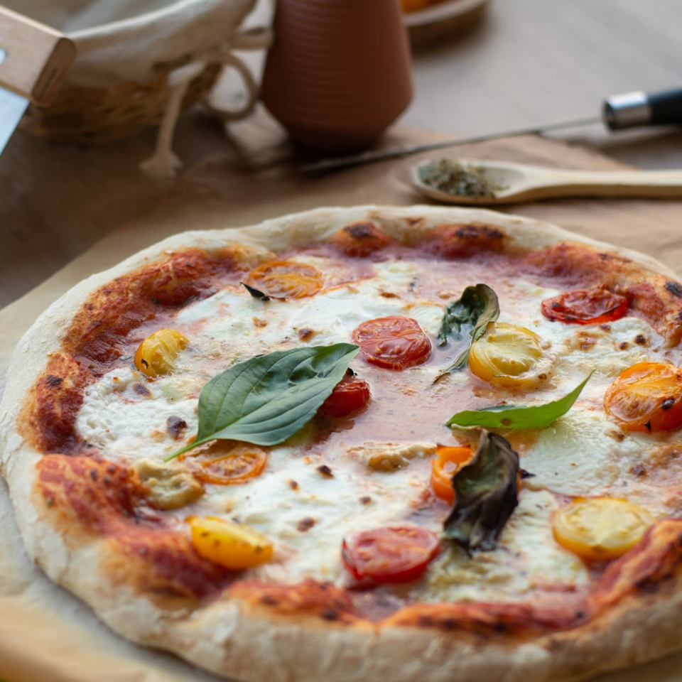 Julius Ristorante's Italian pizza with cherry tomatoes, mozzarella, and fresh basil leaves.